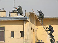 Afghan security forces search for the militants over the roof