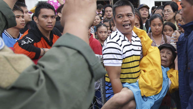 Filipino troopers control survivors who want to board military planes to flee the typhoon ravaged Tacloban city